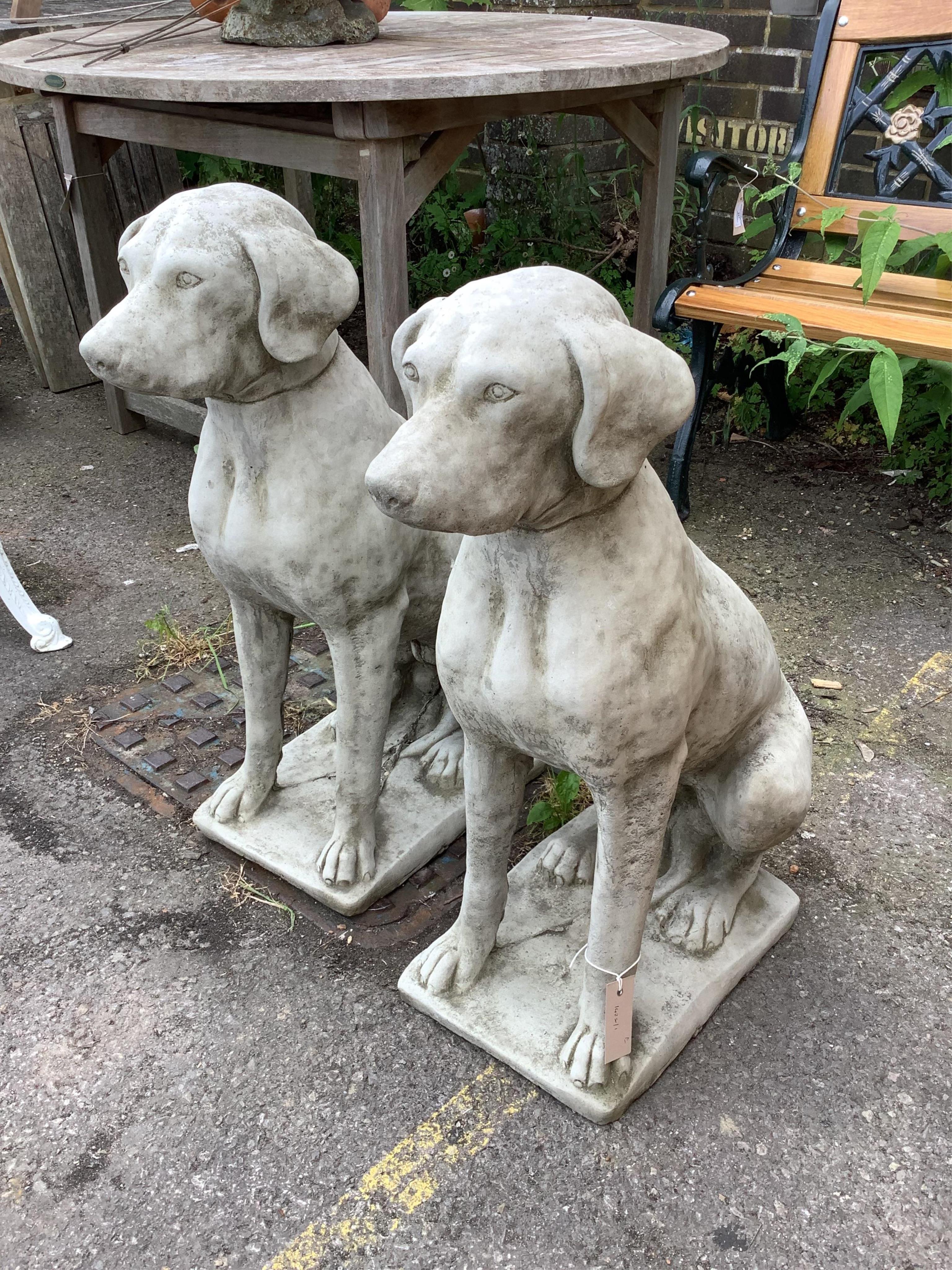 A pair of reconstituted stone seated hound garden ornaments, height 71cm. Condition - good